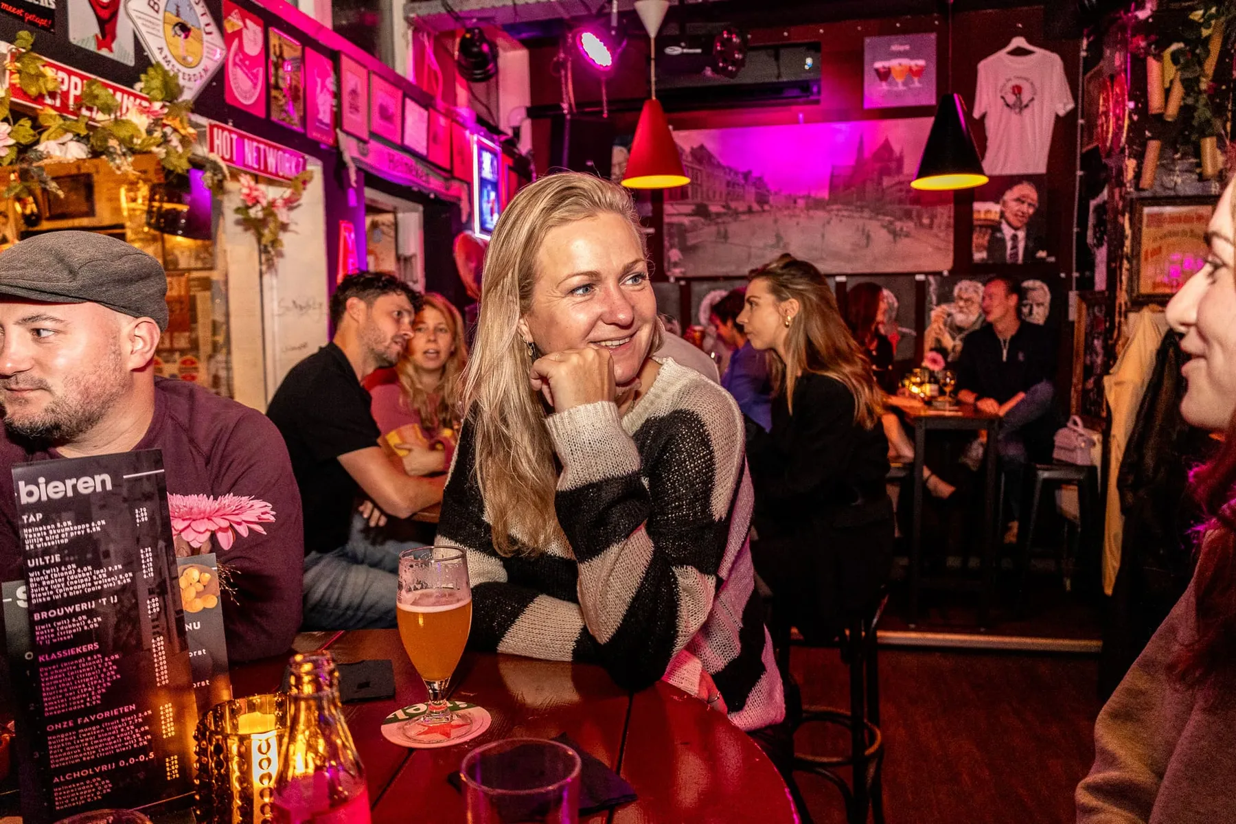 De volle bar van De Lange Heer, met gasten aan de bar en de bediening erachter